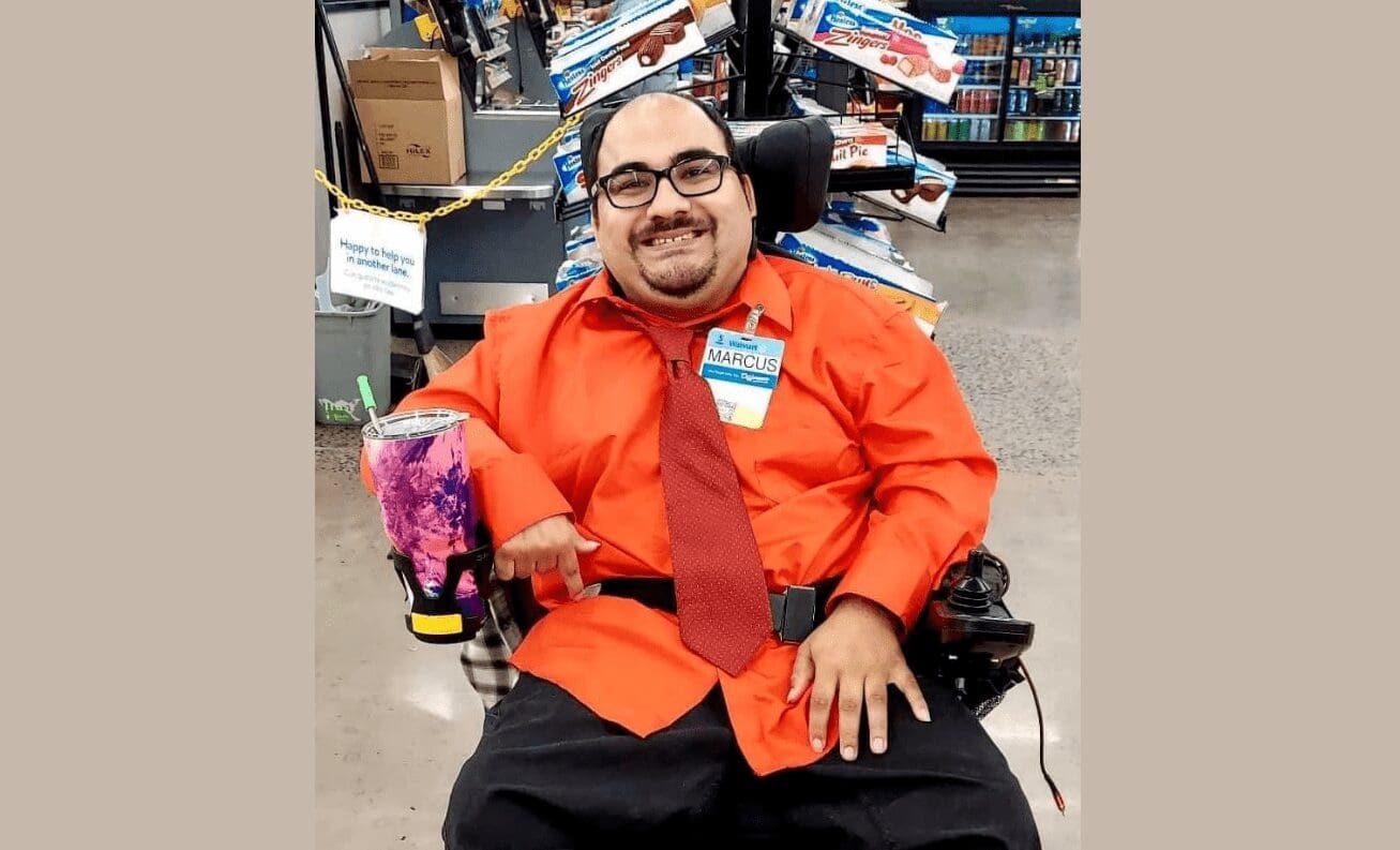 Frontline Manager Leadership Program student Marcus Romer poses in the Walmart checkout area