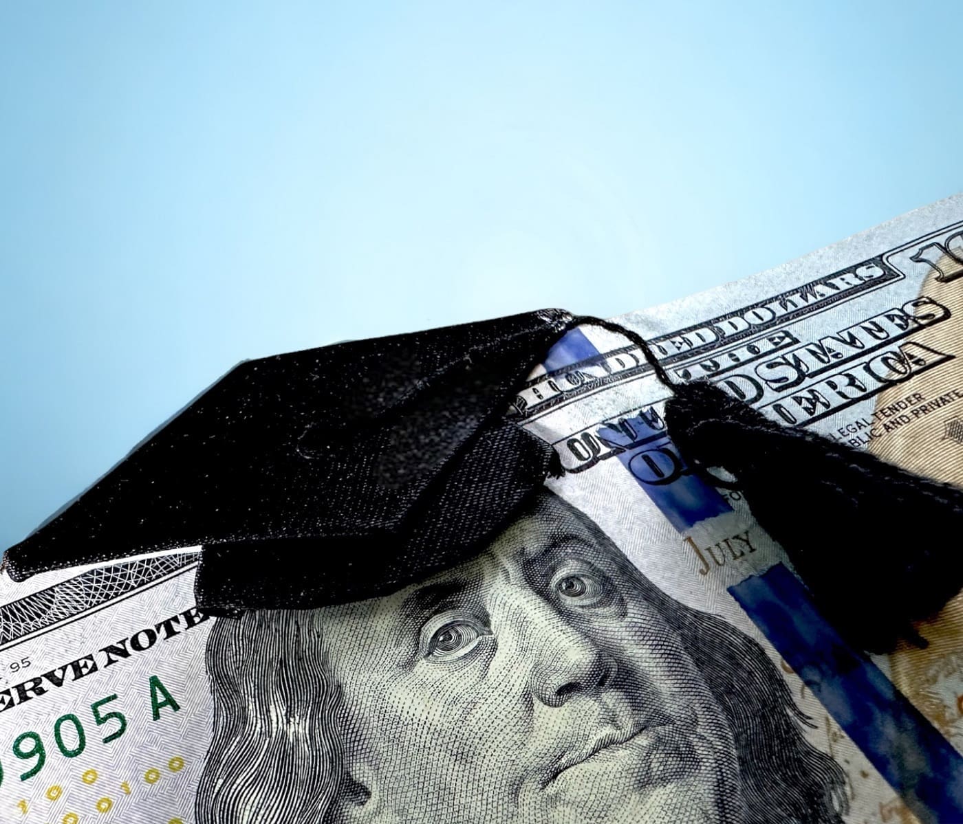 A $100 bill with a small mortar board and tassel sitting atop Benjamin Franklin's head